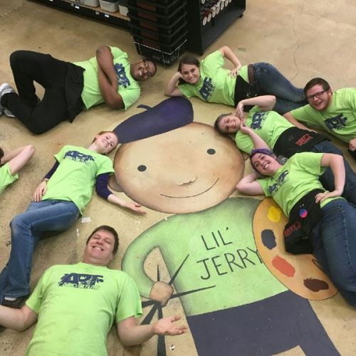 The Staff of Jerry's Artarama Art Supply Store in Raleigh, NC Posing with a Floor Painting of Lil' Jerry